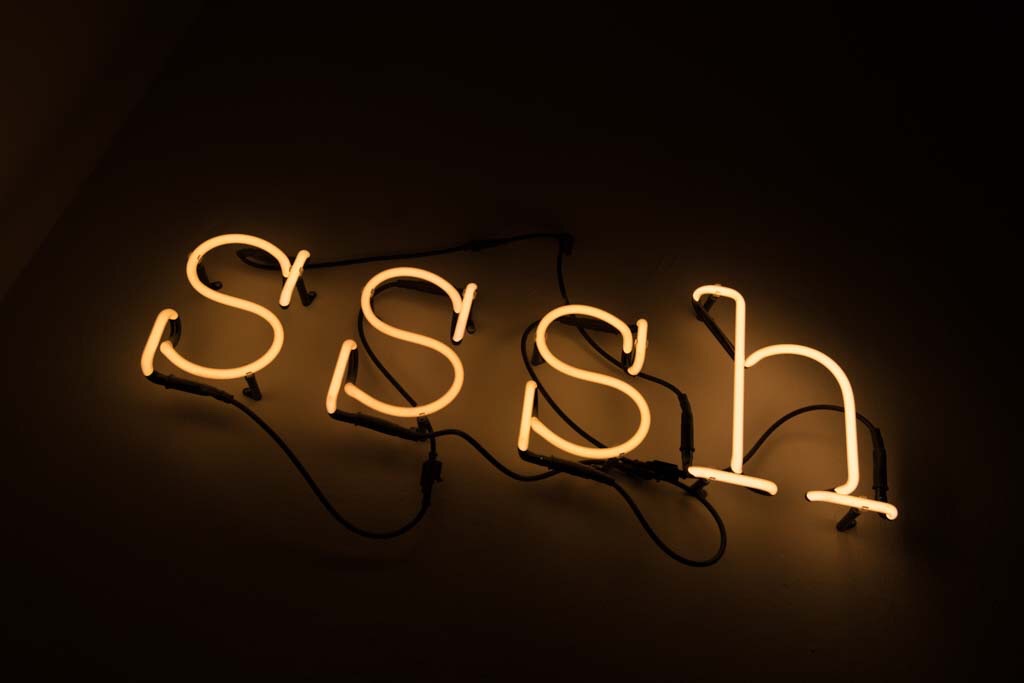 Photo of neon sign that says, "sssh."